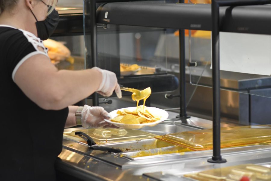 Kitchen manager Kimberly Hill serves nachos to a student during lunch 