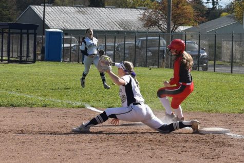 Holloway catches the ball at first base just as a South Albany team member reaches it. 