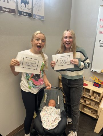 Sophomores Sabrina Ulibarri and Emmery Wells with their fake baby and birth certificate in the Child Development 2 class. 