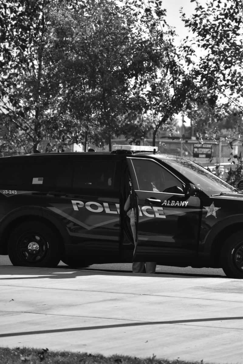 Student getting into parents police car