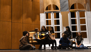 Senior Charlotte Nicholas sings to junior August Slamp, junior Morgan Glenn, elementary school student Cecelia Thompson, senior Nicki Ito, junior Nora Howard, freshman Atlas Coreson, and sophomore Noelle Rowton in rehearsal