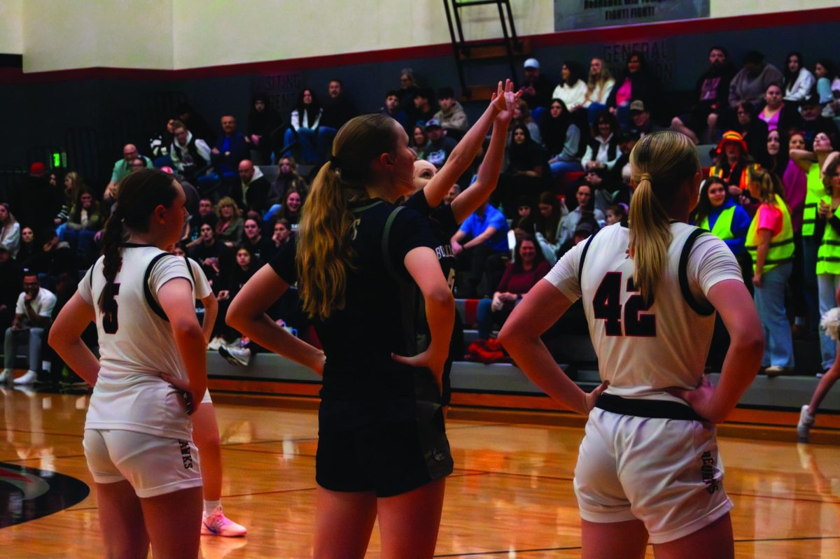 South players McKenna Davis (5) and Kaylee Cordle (42) on either side of junior Lola Chamberlain (3) while sophomore Amelia Timm (5) shoots a free-throw 